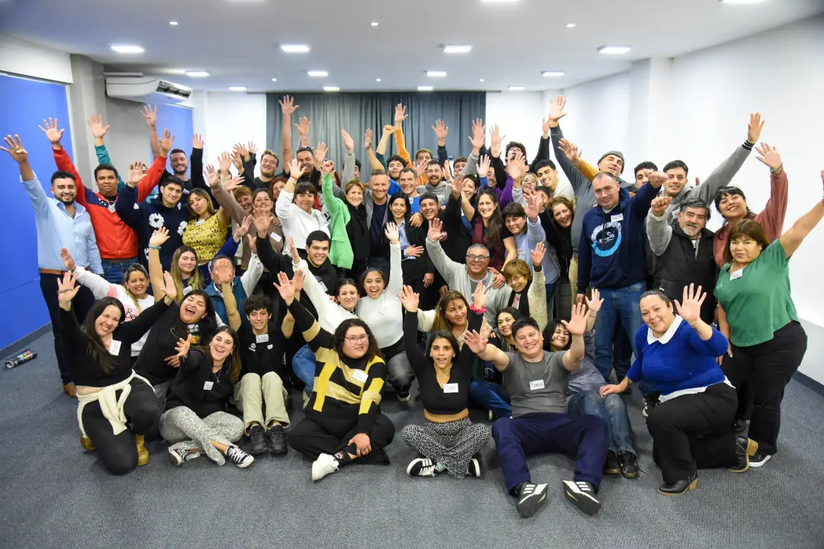 Foto de grupo con participantes celebrando juntos en la sala